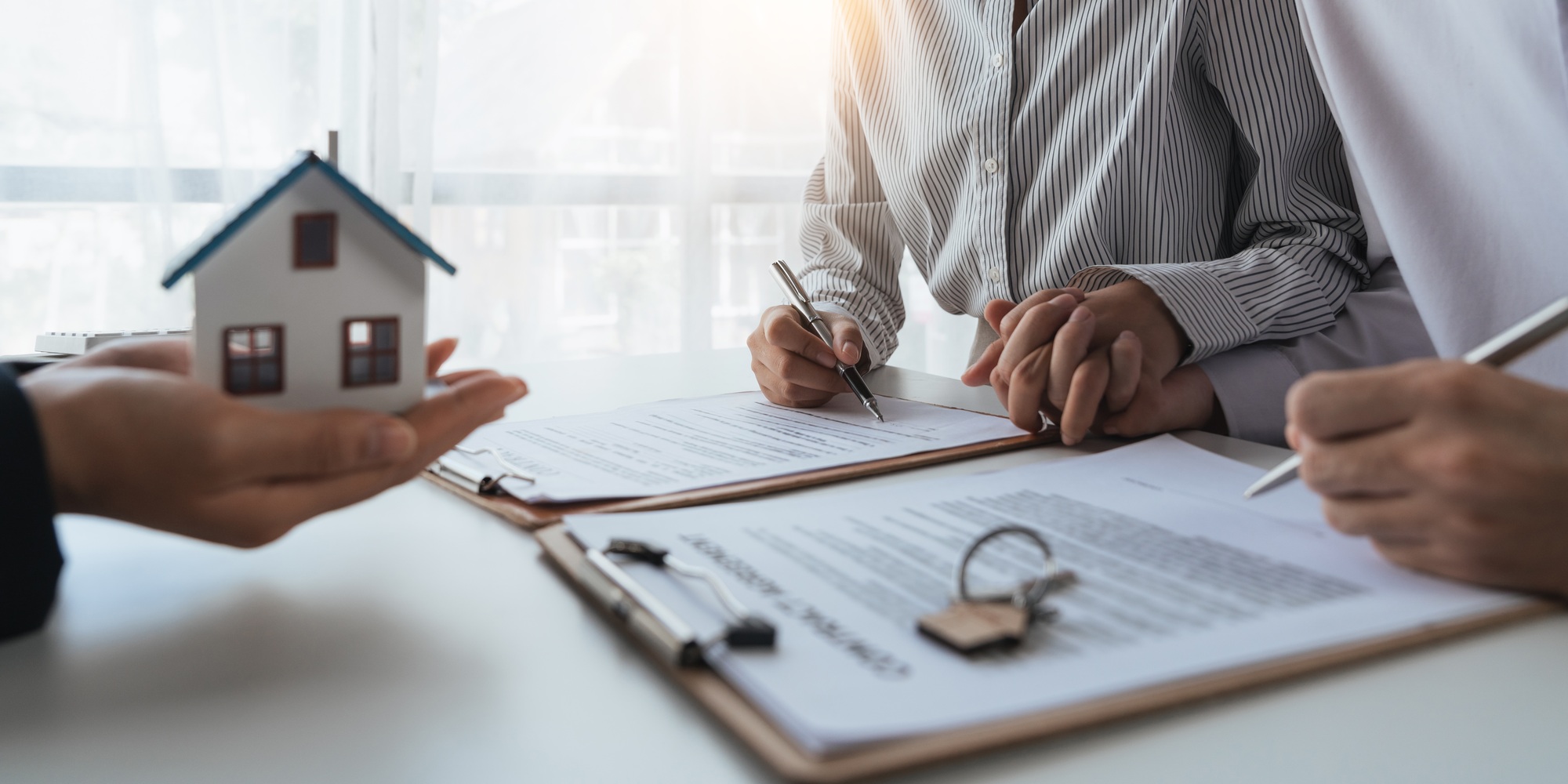 Happy couple signing a contract with real estate agent. renters tenants sign mortgage loan